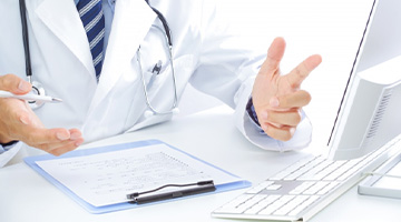 op-select-online パソコン画面に向かって説明をする産業医