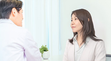 op-select-contract 穏やかな表情で産業医と面談をするスーツを着た女性