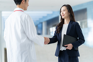オフィスを訪れる医師と出迎える社員のイメージ