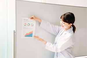 ホワイトボードに資料を提示しながら説明する医師のイメージ